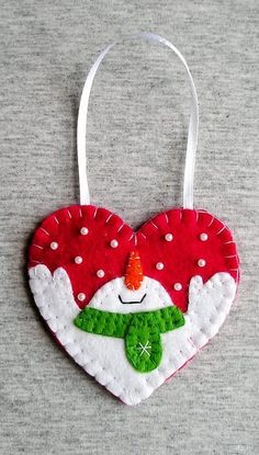 a red heart shaped ornament with a snowman on it