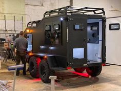 an off - road vehicle is being worked on in a garage with other people around it