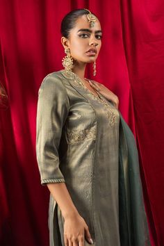 Dark green kurta with dabka, zari, resham, sequin, cutdana, gota embroidery. Paired with pant and dupatta.
Components: 3
Pattern: Embroidery
Type Of Work: Dabka, zari, cutdana, sequin, gota, resham
Neckline: Notched
Sleeve Type: Three quarter
Fabric: Kurta and Pant: Tissue Blend, Dupatta: Pure Organza (100% Silk)
Color: Green
Other Details: 
Sheer embroidered dupatta
Model height: 5 ft 10 inches, wearing size XS
Length Approx.:
Kurta: 46 inches
Pant: 37 - 38 inches
Occasion: Sangeet - Aza Fashio Elegant Green Unstitched Suit With Cutdana, Fitted Gold Tussar Silk Sets, Elegant Unstitched Pista Green Suit With Cutdana, Tussar Silk Party Sets With Zari Work, Pista Green Tussar Silk Set With Zari Work, Elegant Pista Green Unstitched Suit With Cutdana, Gold Cotton Silk Sets With Dabka Detail, Pista Green Raw Silk Sets With Dabka Detail, Tussar Silk Sets For Navratri Party