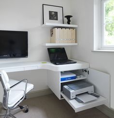 a white desk with a laptop computer on top of it next to a chair and window