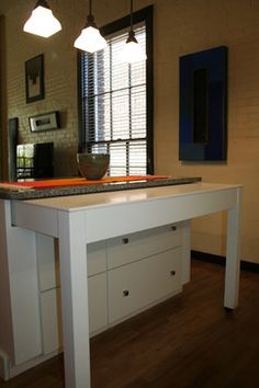 a white table with drawers under two lights