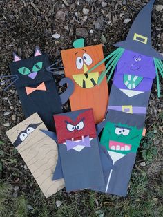 several paper bags with cats and witches on them sitting in the grass next to each other