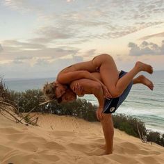 a woman doing a handstand on the beach