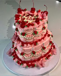 a three tiered cake with pink frosting and red flowers