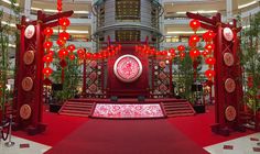 an elaborately decorated area with red lanterns and decorations in the center, surrounded by tall trees