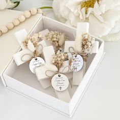 a box filled with white flowers next to a wooden bead necklace and bracelet on top of a table