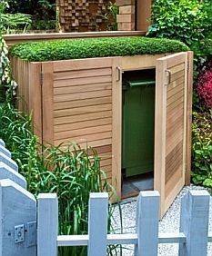 a small wooden outhouse in the middle of a garden