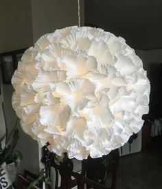 a large white paper flower hanging from a ceiling