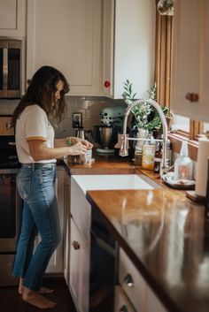 a woman standing in a kitchen preparing food