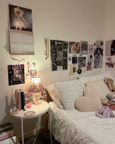 a white bed sitting next to a wall covered in pictures