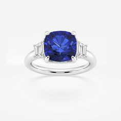 a blue sapphire and diamond ring with three baguets on the shoulders, set in white gold