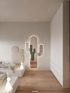 a room with white walls and wooden floors has a cactus shaped mirror on the wall