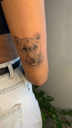 a woman's arm with a small tattoo of a lion