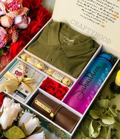 the contents of a gift box are laid out on a bed with flowers and candles