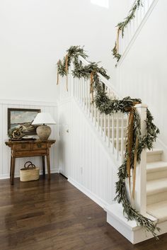 the stairs are decorated with garland and pine cones for holiday decor, along with other decorations