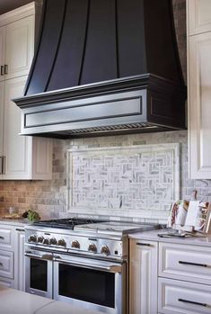 a stove top oven sitting inside of a kitchen next to white cabinets and counter tops