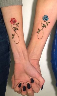 two people holding hands with tattoos on their arms and one is holding the other's hand