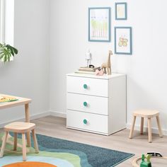 a child's room with white furniture and toys