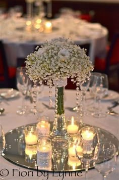 a centerpiece with flowers and candles on a table