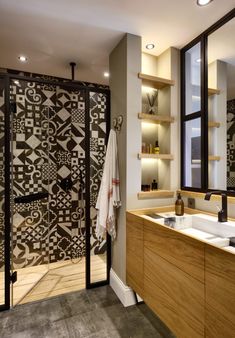 a bathroom with two sinks and a large mirror in it's center, next to a walk in shower