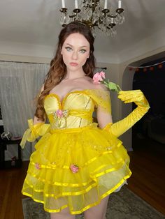 a woman in a yellow dress holding a rose