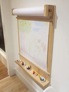 a white toilet sitting next to a wooden shelf filled with small cups and saucers