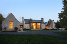 a large brick house sitting on top of a lush green field