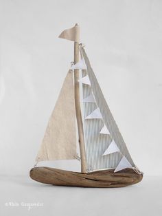 a small sailboat made out of wood and paper