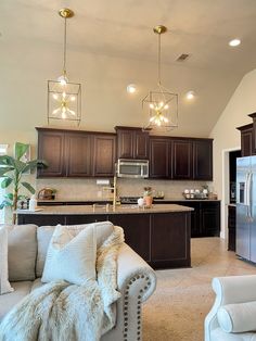 a living room filled with furniture next to a kitchen