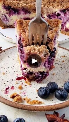 a piece of blueberry crumb cake on a plate with a fork in it