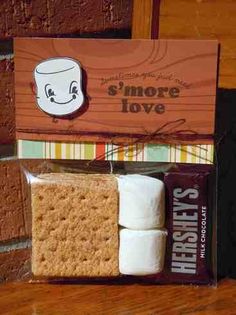 marshmallows and s'more in a package on a wooden table next to a sign