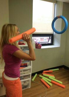 a woman is playing with an inflatable ball and some carrots on the floor