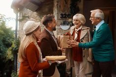 an elderly couple handing food to two women