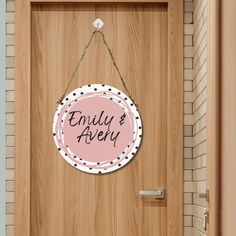 a wooden door with a pink sign hanging from it's side