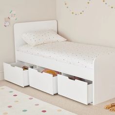 a child's bed with storage drawers underneath it in the corner of a room