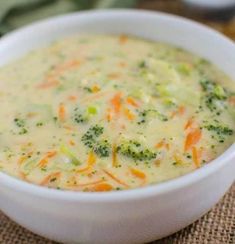 a white bowl filled with broccoli and carrots on top of a table