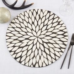 a white and black plate sitting on top of a table next to utensils