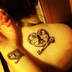 two people with tattoos on their backs holding keys and heart shaped keyhole tattoo designs