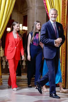 a man in a suit and tie walking with other people