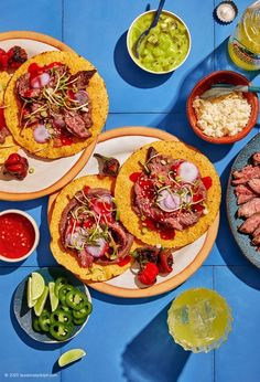 three plates with food on them sitting on a table next to bowls of sauces and condiments