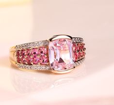 Elevate your jewelry collection with the mesmerizing elegance of the Sterling Silver Pink Kunzite Solitaire Ring in Rose Gold. This exquisite piece features a captivating pink kunzite, beautifully measured at 9x7mm in a cushion shape, set in a half bezel setting that highlights its natural beauty. The band, adorned with tension-set pave pink tourmalines and accented with dazzling white zircons, is plated with a luxurious 1-micron thickness of 14k rose gold. Key Features: Stunning Pink Kunzite: T Half Bezel Setting, Half Bezel, Pink Kunzite, Rectangular Cushion, Gold Key, Pave Band, Rose Gold Band, Zircon Ring, Pink Ring