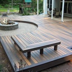 a wooden deck with benches and fire pit