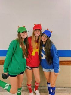 three girls dressed up in costumes posing for the camera