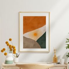 an abstract painting hangs on the wall next to a wooden table with vases and flowers