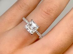 a woman's hand with an engagement ring on it and a diamond in the middle