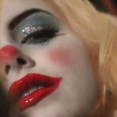 a close up of a woman with makeup on her face and red eyeshadow