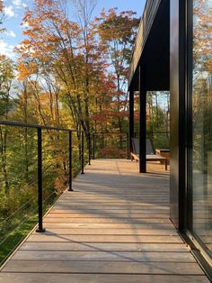 a wooden deck with railings leading to trees