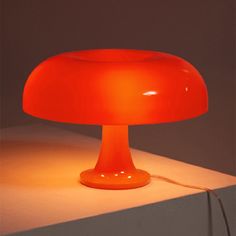 an orange lamp sitting on top of a table