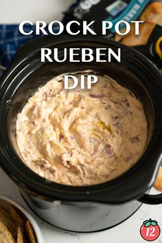 crock pot reuben dip in a black crock pot with crackers on the side