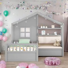 a child's bedroom decorated in pastel colors with balloons and streamers on the ceiling